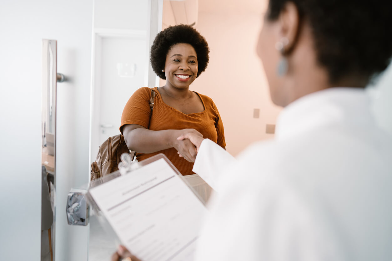 Young woman shaking hands with her doctor.