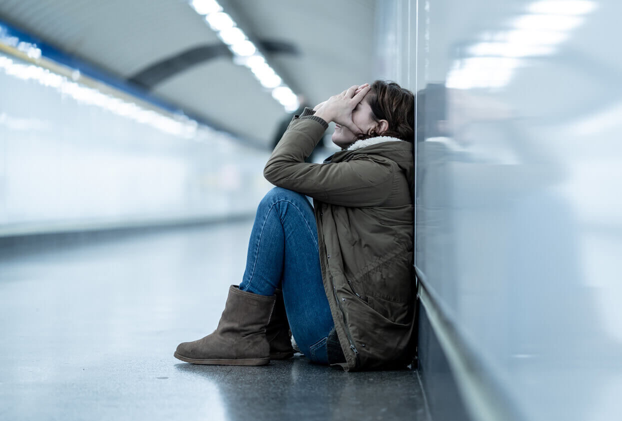 A young adult experiences anxiety attacks, causing feelings of shame, depression, and hopelessness while sitting alone on the subway floor.