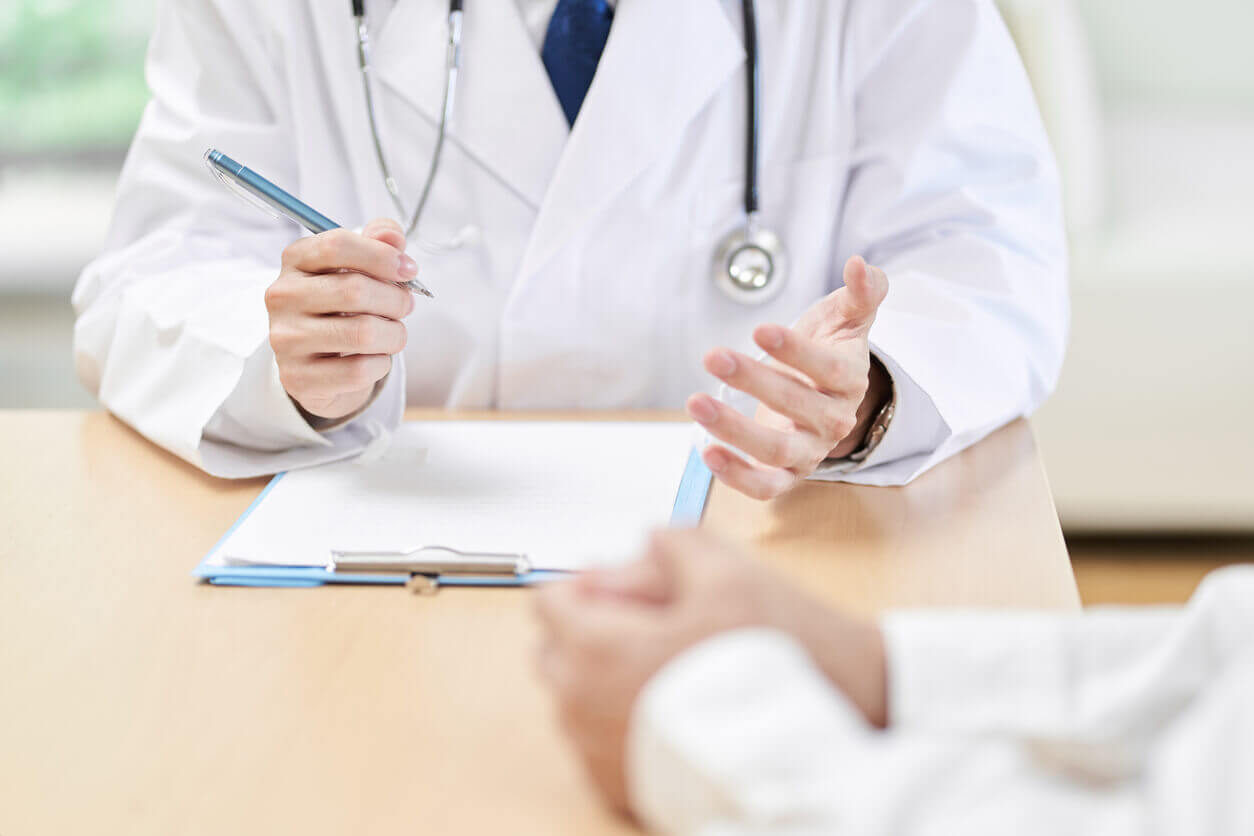 Hands of a primary care doctor explaining symptoms to the patient during primary care and psychiatric services.