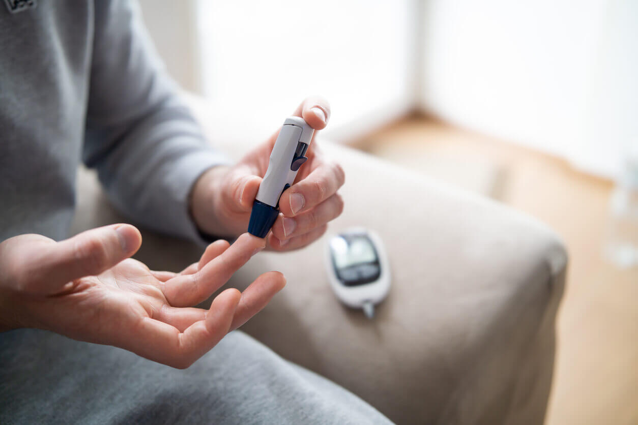 Image Of A Diabetic Man's Hand Checking Blood Sugar Level With Glucometer.