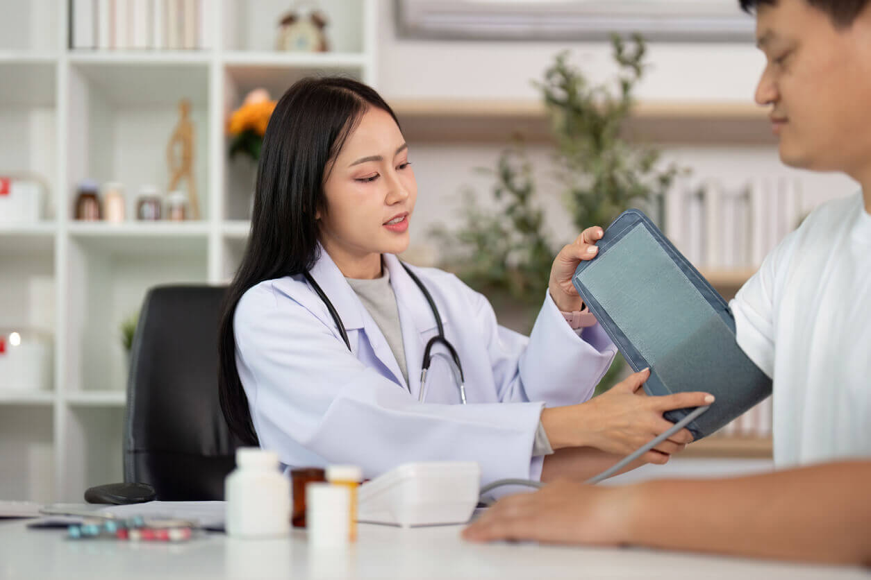 Preventative health care doctor checking blood pressure of patient in medical office