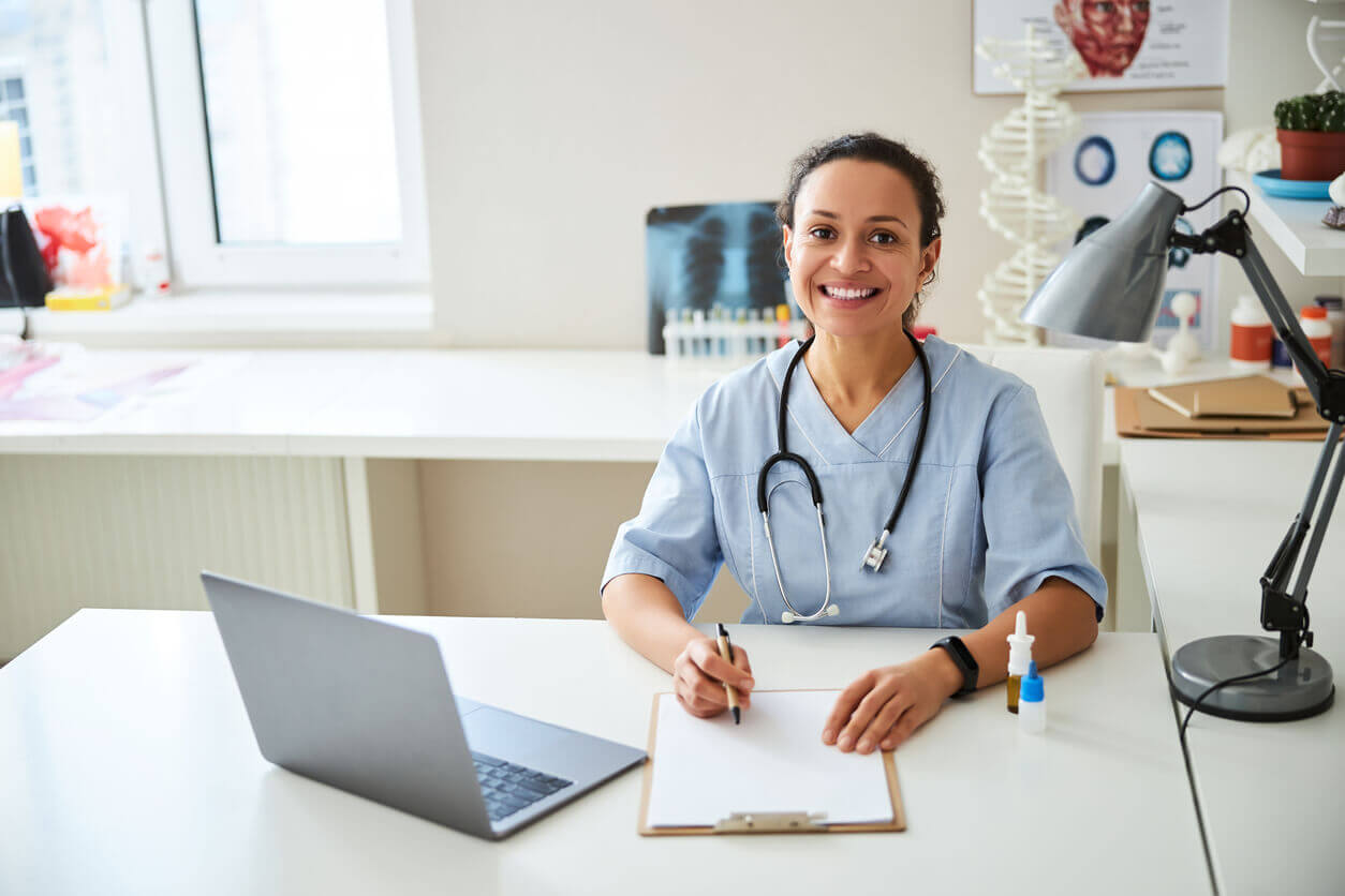A female primary care provider sitting in a medical office over a notepad.