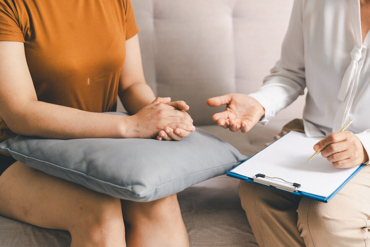 Close-up of a patient sitting with a anxiety health counselor in a professional therapy session.