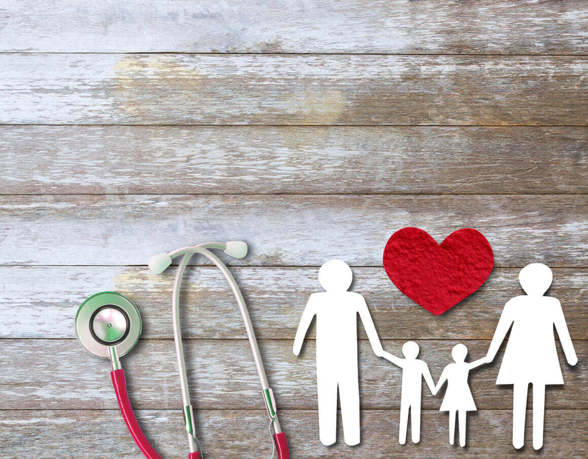 Paper cut of family on wood table top view with stethoscope, to represent family medicine.