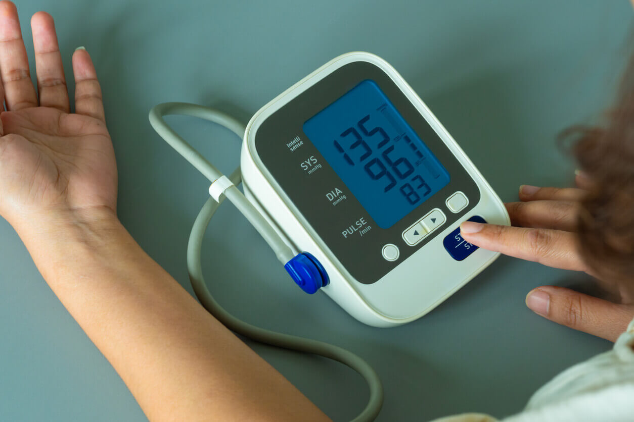 Woman checks blood pressure monitor and heart rate monitor with digital pressure gauge.